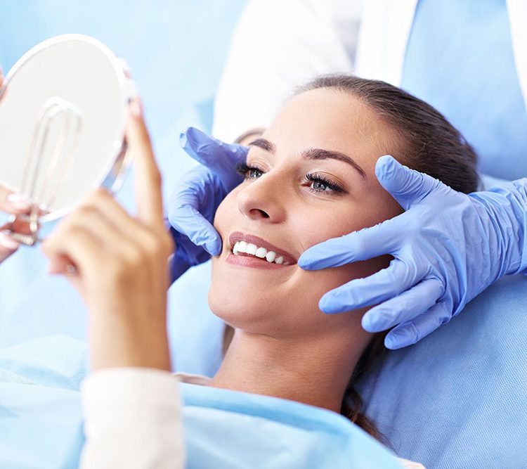cosmetic dentist showing lady smile in mirror